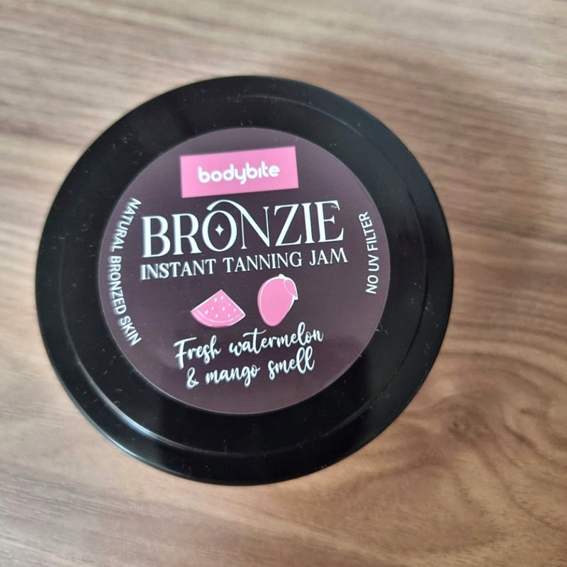 Bodybite BRONZIE Instant Tanning Jam with Watermelon and Mango in a stylish jar on a wooden surface